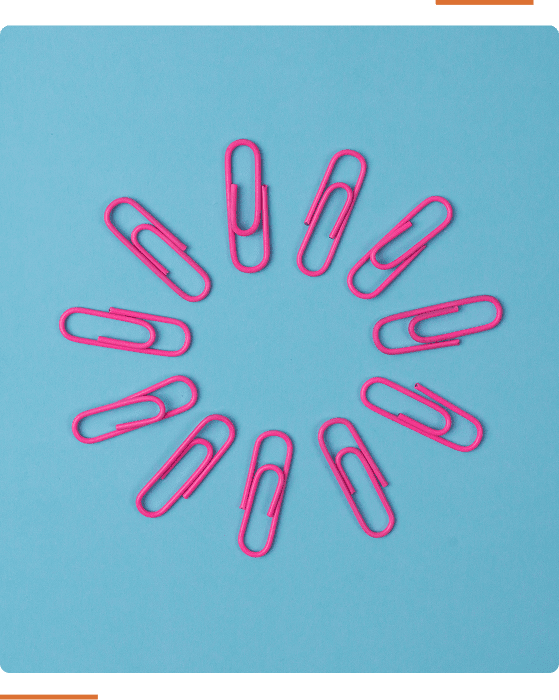 A circle of pink paperclips arranged on a blue background.