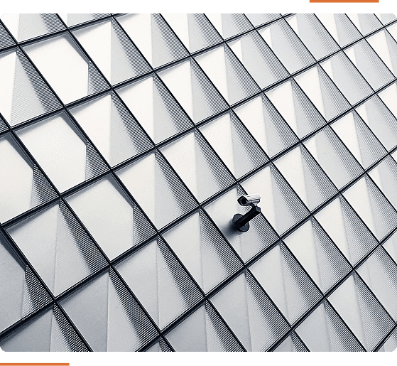 Geometric pattern with raised diamond-shaped panels and a lone security camera mounted on a wall.